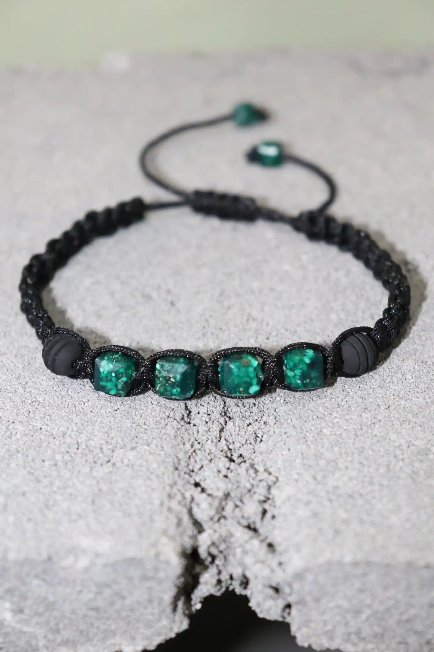 Pulsera con cuatro esmeraldas cuadradas naturales encapsuladas, resaltando el vibrante verde de las esmeraldas colombianas y dos esferas de neopreno, joyería moderna